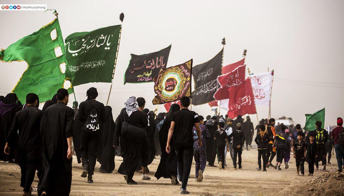 Pilgrims walking side by side along the road from Najaf to Karbala during Arbaeen