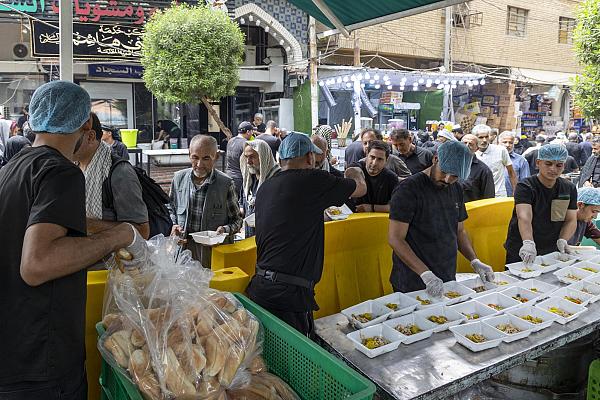 Volunteers at a mawkib serving free food and water to pilgrims along the Arbaeen route
